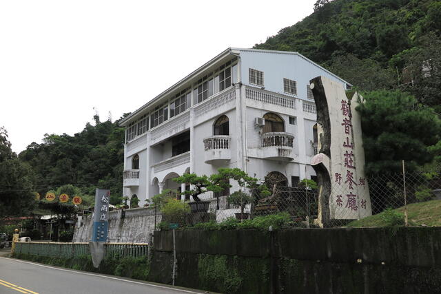 觀音山莊餐廳招牌聳立在路旁,觀音山莊餐廳